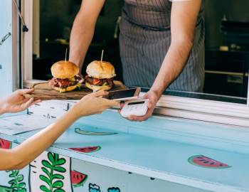 person paying for 2 burgers from a food truck