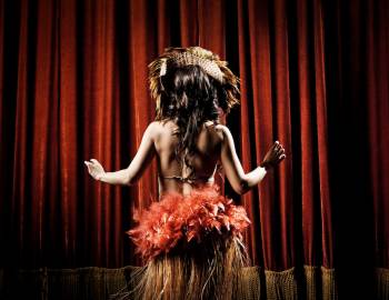hula dancer in front of red curtain