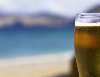 beer with blurry beach in background