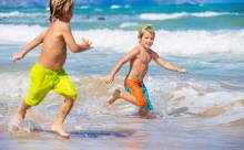 two boys running in the surf 