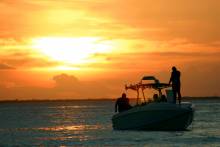 silhouette of a fishing boat at sunset on the water 