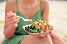 Woman eating a poke bowl