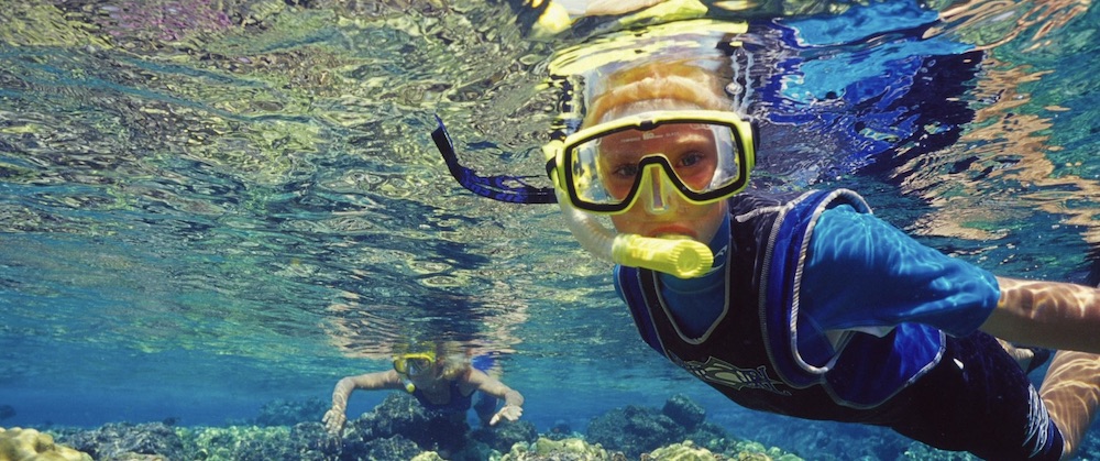 Two children snorkel in Maui