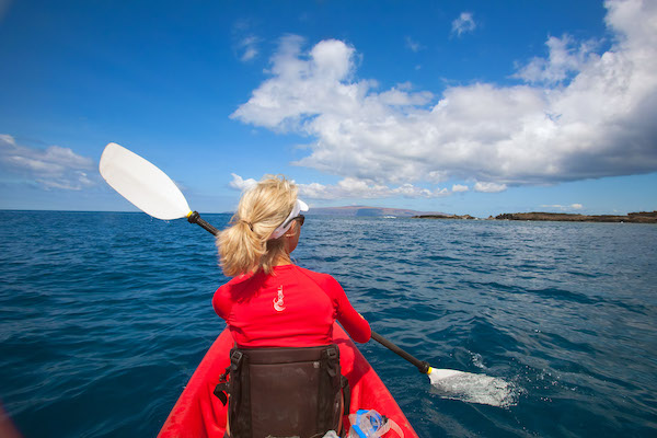 A woman kayaking off the coast of Maui