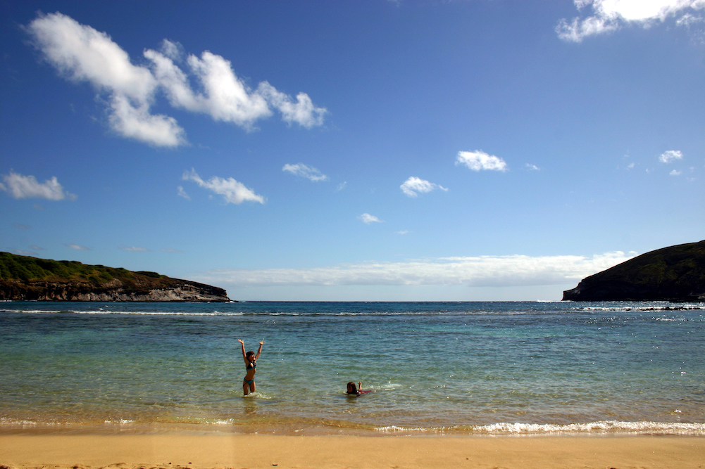 two people playing in calm waters in maui