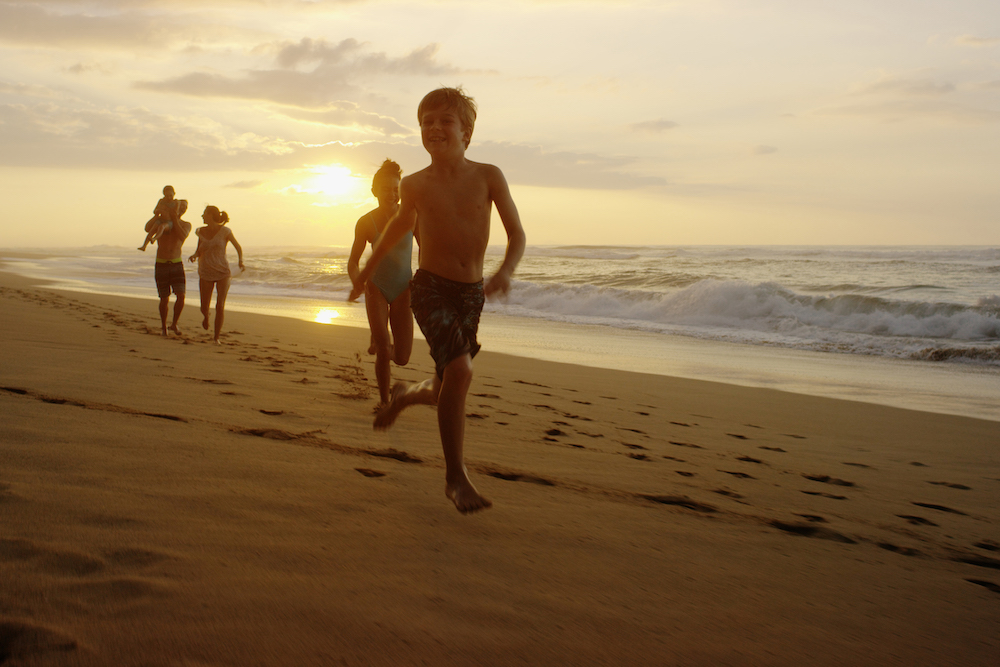 family running on beach